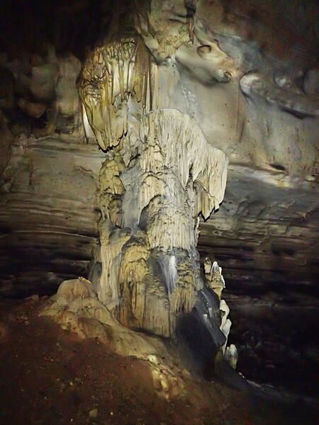 Jeskyně Kobyla – mohutný stalagnát pod vstupní propastí, zem pokrývá netopýří guano