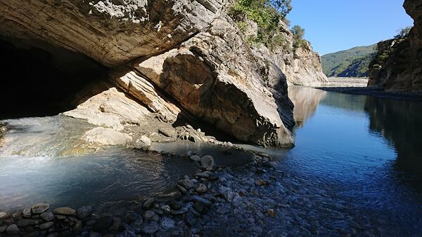 Ze vstupního portálu jeskyně Sulfur v soutěsce Vromoner vytéká voda teplá 26 °C