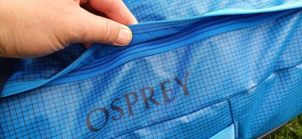 Taška Osprey Transporter 65 Uni – kvalitní zip je chráněn proti proniknutí vody do zavazadla přesahujícím lemem 