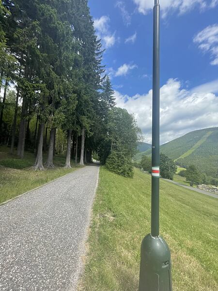Tady se napojí na silnici a červené turistické značení povede až na hřebeny