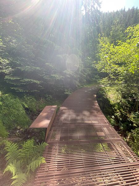 Po modré vede pod stohem trasa přes dvě lávky, jednu ocelouvou, druhou dřevěnou